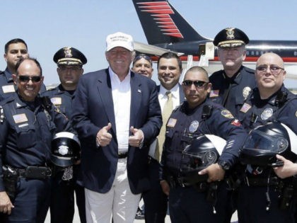Republican presidential hopeful Donald Trump, center, poses for a photo with Laredo Police officers before Trump's departure from Laredo, Texas, Thursday, July 23, 2015. (AP Photo/LM Otero)