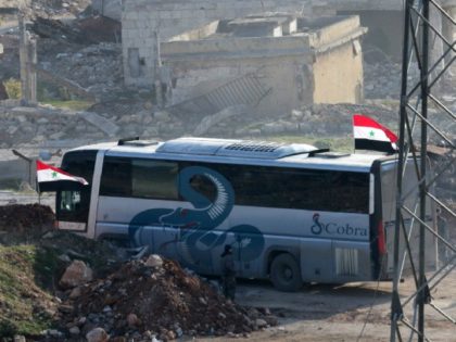 A bus drives through the Syrian government-controlled crossing of Ramoussa, on the southern outskirts of Aleppo, on December 18, 2016, during an evacuation operation of rebel fighters and civilians from rebel-held areas. / AFP / George OURFALIAN (Photo credit should read GEORGE OURFALIAN/AFP/Getty Images)
