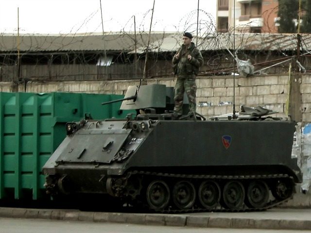 A Lebanese army soldier stands on an M113 Armored Personnel Carrier (APC) deployed in Beir