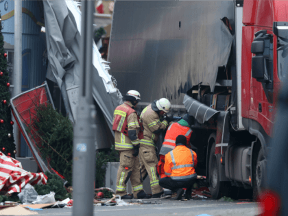 Rescue workers begin to remove the rear of the lorry the morning after it ploughed through