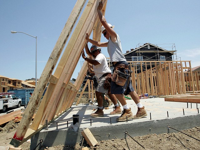 RICHMOND, CA - JUNE 26: Construction workers lift timber framing as they build homes in a new housing development on June 26, 2006 in Richmond, California.  A report released by the US Department of Commerce said sales of new single-family homes rose 4.6% in May.  The median price of homes sold in May slipped to $235,300, down 4.3% from April.  (Photo by Justin Sullivan/Getty Images)