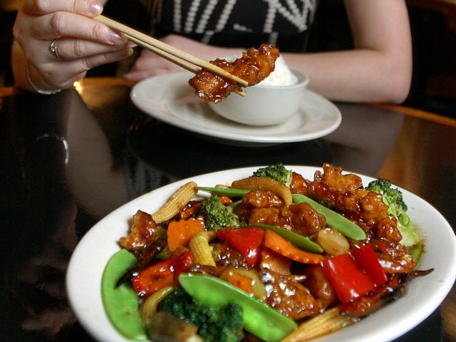 FILE- In this July 22, 2004 file photo, Tong Xian Mei, of Ollie's Restaurant, samples from