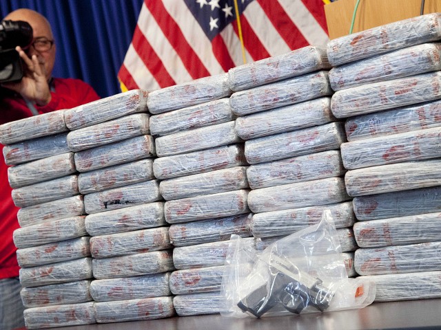 A firearm and 154 pounds of heroin worth at least $50 million are displayed at a Drug Enforcement Administration news conference, Tuesday, May 19, 2015 in New York. The DEA called the heroin seizure its largest ever in New York state. Officials said on Tuesday that most of the drugs were found in an SUV in the Bronx following a wiretap investigation. (AP Photo/Mark Lennihan)