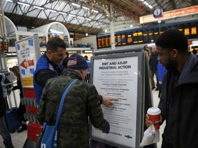 A passenger looks at a board detailing industrial action by …