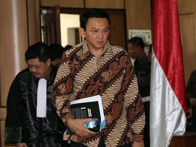 Jakarta Governor Basuki Tjahaja Purnama (2nd L), popularly known as 'Ahok', arrives at the court room before his trial for blasphemy at the North Jakarta District Court in Jakarta on December 13, 2016. Jakarta's Christian governor choked back tears on December 13 as he gave an impassioned defence against charges …