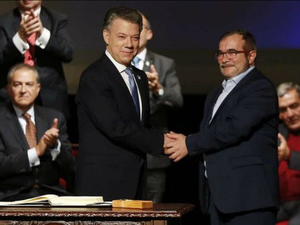 Colombia's President Juan Manuel Santos, front left, shakes hands with Rodrigo Londono, known as Timochenko, top leader of the Revolutionary Armed Forces of Colombia, FARC, after signing a revised peace pact at Colon Theater in Bogota, Colombia, Thursday, Nov. 24, 2016. An original accord ending the half century conflict was …
