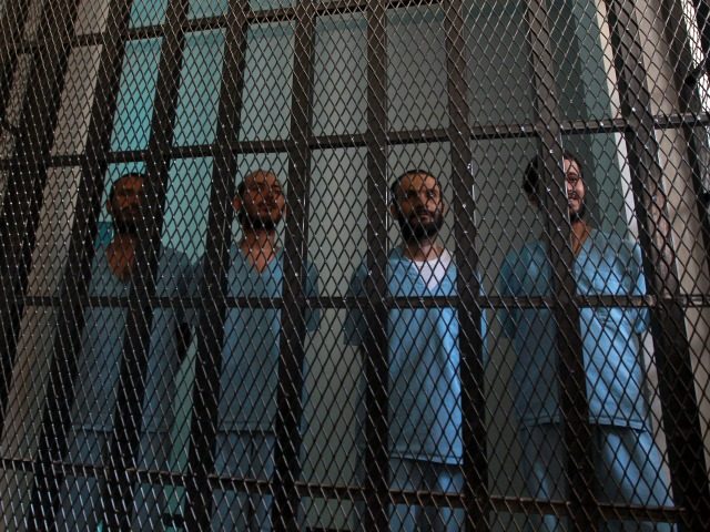 Prisoners stand in their holding cell at the court room of a state security court during t