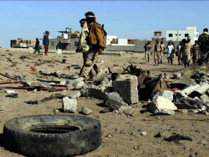 Soldiers gather the site of a suicide bomb at a base in the southern city of Aden, Yemen,