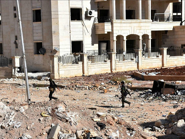 Syrian pro-government soldiers cross a road '3000' apartment block area, in al-Hamdaniyah,