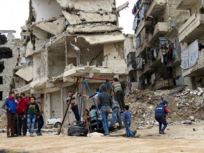 TOPSHOT - Syrian children play in a government-held area of Aleppo on December 16, 2016. Russia announced it was negotiating with the Syrian opposition and seeking a nationwide ceasefire, as the evacuation of civilians and fighters from the last rebel-held parts of Aleppo entered a second day. The Syrian Observatory …