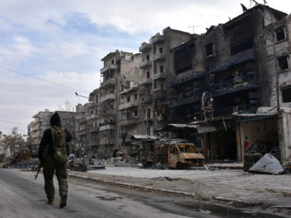 Syrians regime forces walk past destroyed buildings in the former rebel-held Ansari district in the northern city of Aleppo on December 23, 2016 after Syrian government forces retook control of the whole embattled city. Syrian troops cemented their hold on Aleppo after retaking full control of the city, as residents …