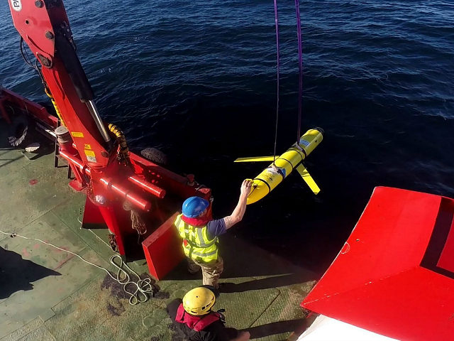 Crew members aboard the VOS Raasay recover U.S. and British Royal Navy ocean gliders takin