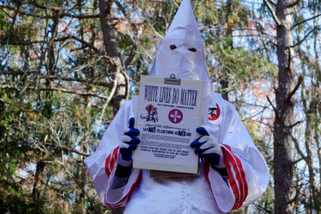 A member of the Ku Klux Klan who says his name is Gary Munker poses for a photo during an