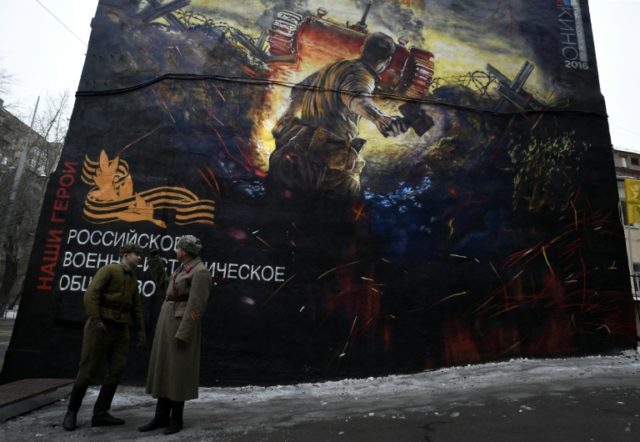 Men dressed in Red Army World War II uniforms take part in the opening of a street art-sty