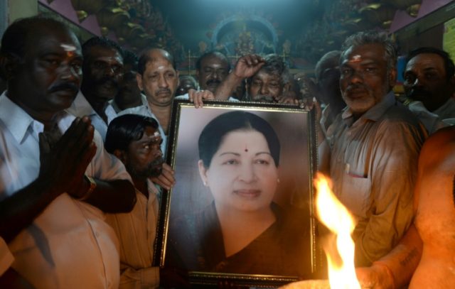 Supporters hold a photograph of Tamil Nadu state leader Jayalalithaa Jayaram as they offer