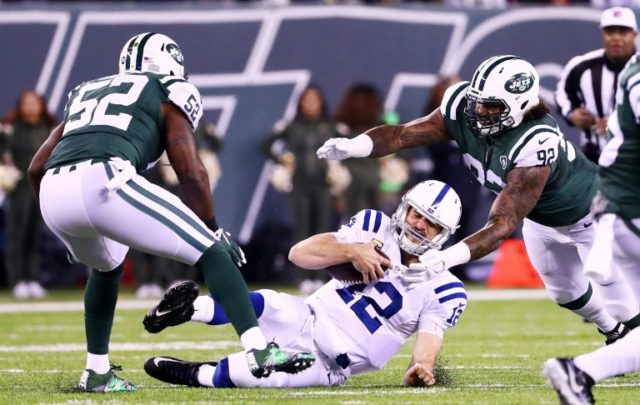 Andrew Luck of the Indianapolis Colts slides down against the New York Jets' defense of Le