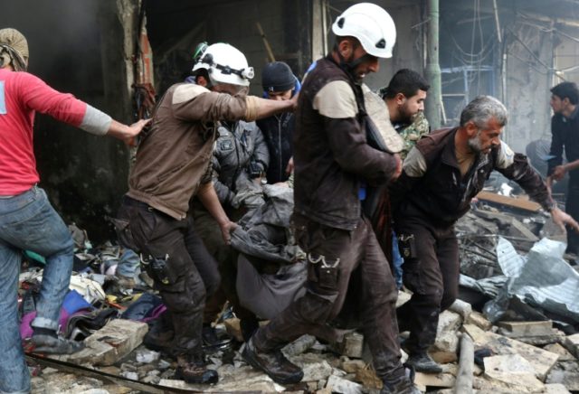 Syrian men and Civil Defence volunteers, also known as the White Helmets, evacuate a victi