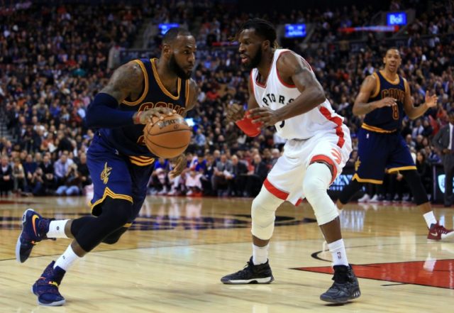 LeBron James of the Cleveland Cavaliers dribbles the ball past DeMarre Carroll of the Toro