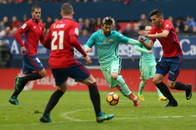 Barcelona's Argentinian forward Lionel Messi (centre) vies with Osasuna's defender David G
