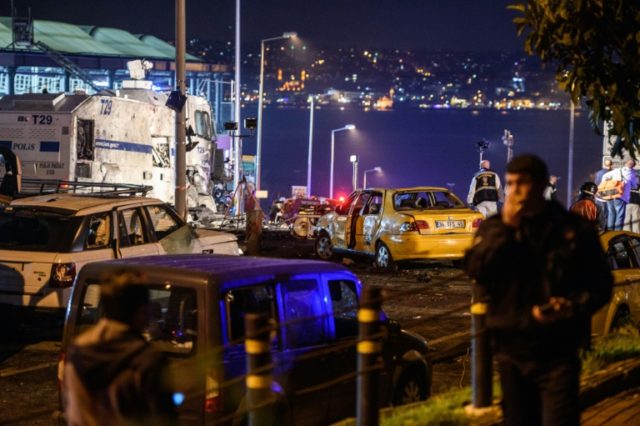 Turkish police officers and forensic work next to damaged police vehicles and cars on the