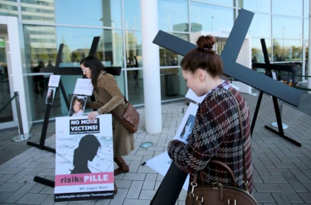 Women carry crucifixes with photos of women who died after taking contraceptives produced