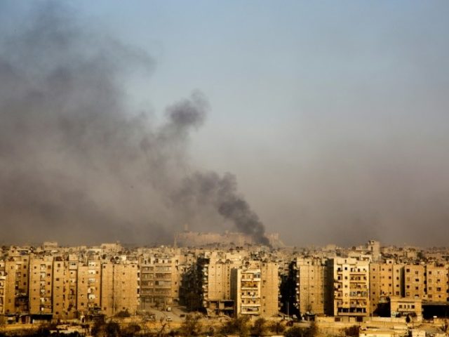 Smoke billows from the former rebel-held district of Bustan al-Qasr in Aleppo, on December