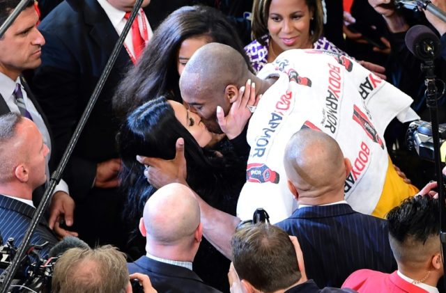 Kobe Bryant of the Los Angeles Lakers kisses his wife Vanness following his last game as a