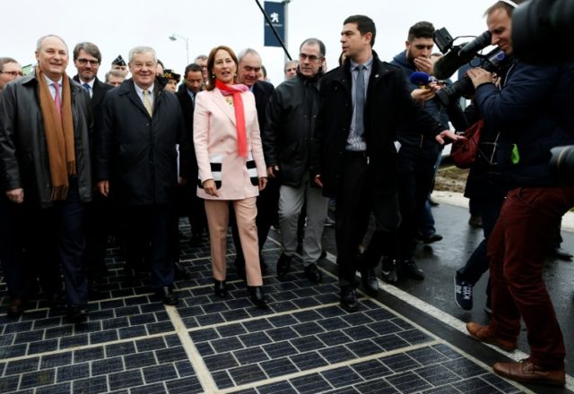 Segolene Royal and other officials walk on a solar panel road at its inauguration in Touro