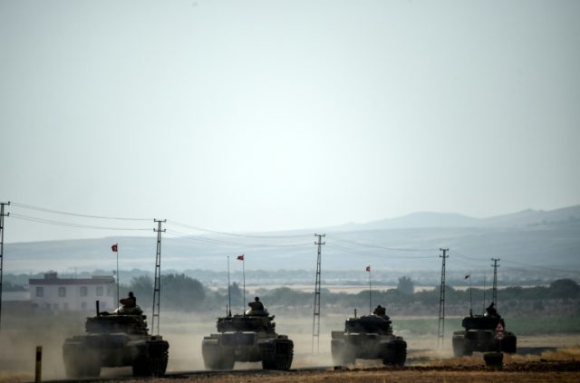 Turkish Army tanks drive to the Syrian Turkish border town of Jarabulus on August 25, 2016