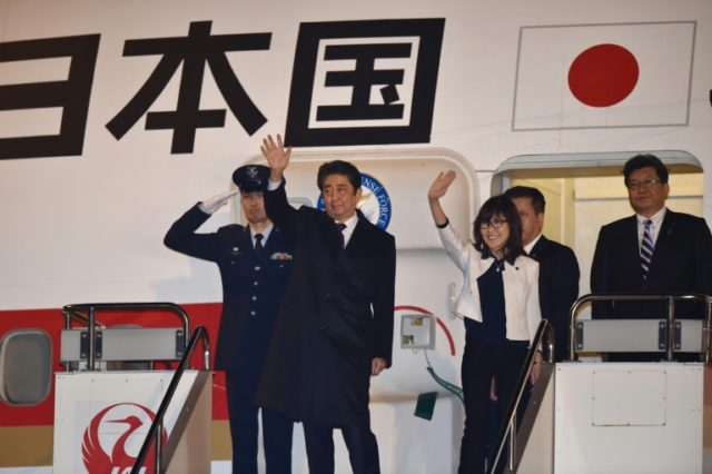 Japan's Prime Minister Shinzo Abe (2nd L) and Defense Minister Tomomi Inada (3rd L) wave a