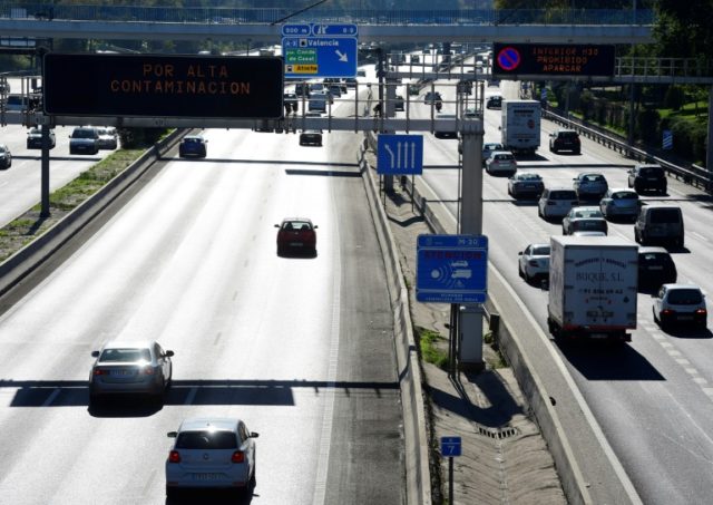 Vehicles on the M30 motorway in Madrid pass under road signs reading speed limitation due