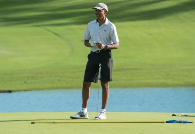 US President Barack Obama retrieves his ball after putting on the 18th green at the Kapolei Golf Club in Kapolei on December 21, 2016 during his annual Christmas vacation in Hawaii