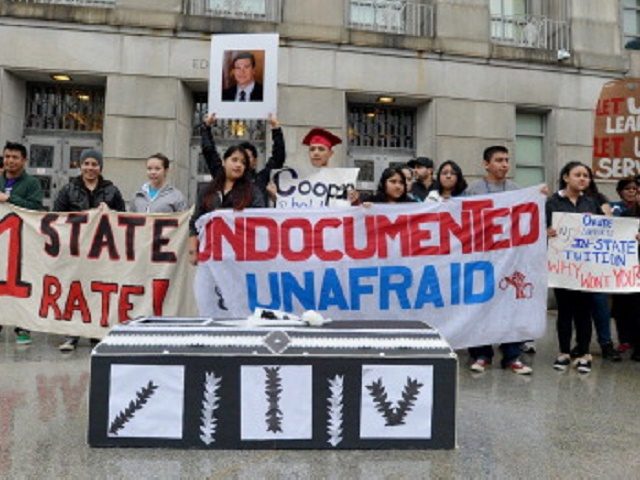 More than 20 immigration activists chant slogans and brandish banners on the front steps o