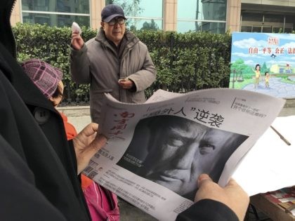 FILE - In this Nov. 10, 2016 file photo, a Chinese man holds up a Chinese newspaper with the front page photo of U.S. President-elect Donald Trump and the headline "Outsider counter attack" at a newsstand in Beijing, China. China views a Trump presidency with less trepidation. It has viewed …
