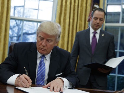 President Donald Trump signs an executive order to withdraw the U.S. from the 12-nation Tr