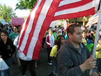 Julio Guzman, 20, carries a flag during a march for immigration reform on Wednesday, May 1, 2013 in Yakima, Wash. (AP Photo/Shannon Dininny)