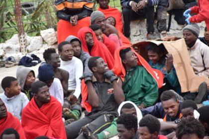 Migrants sit on the ground in El Tarajal, Ceuta, close to the boarder with Morocco on Dece