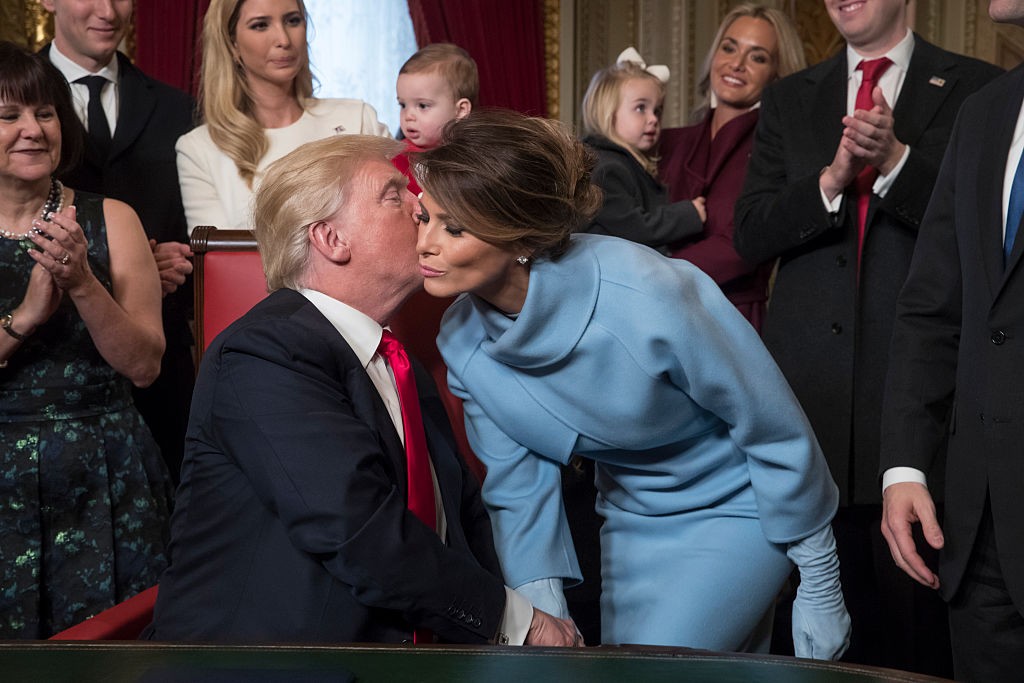 WASHINGTON, DC - JANUARY 20: President Donald Trump kisses his wife Melania Trump as he is joined by the Congressional leadership and his family to formally signs his cabinet nominations into law, in the President's Room of the Senate, at the Capitol in Washington, January 20, 2017. (Photo by J. Scott Applewhite - Pool/Getty Images)