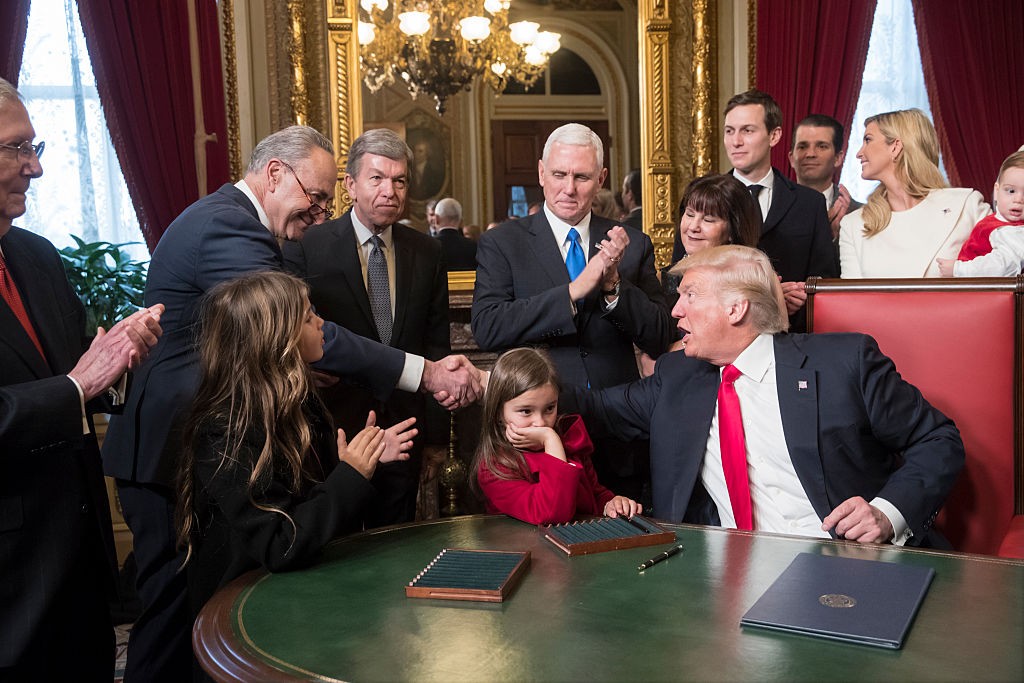 WASHINGTON, DC - JANUARY 20: President Donald Trump shakes hands with Senate Minority Leader Chuck Schumer, D-N.Y, as he is joined by the Congressional leadership and his family while he formally signs his cabinet nominations into law, in the President's Room of the Senate, at the Capitol in Washington, January 20, 2017. From left are Senate Majority Leader Mitch McConnell, R-Ky., Senate Minority Leader Chuck Schumer, D-N.Y, Sen. Roy Blunt, R-Mo., Vice President Mike Pence and his wife Karen Pence, Jared Kushner, Donald Trump Jr., and Ivanka Trump. (Photo by J. Scott Applewhite - Pool/Getty Images)