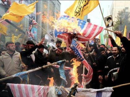 Iranians burn US flags outside the former US embassy in Tehran on November 4, 2013, during a demonstration to mark the 34th anniversary of the 1979 US embassy takeover. Thousands of Iranians shouted 'Death to America' as they demonstrated 34 years after Islamist students stormed the embassy compound in Tehran, …