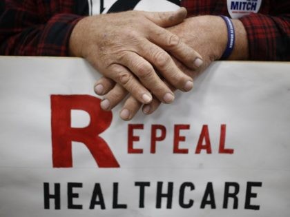 LOUISVILLE, KY - OCTOBER 31: Supporter James Hughes of Louisville, Ky. holds a sign calling for the repeal of the Affordable Care Act during a rally for Senate Minority Leader Mitch McConnell (R-KY) at Brandeis Machinery & Supply Company on October 31, 2014 in Louisville, Kentucky. With less than a …