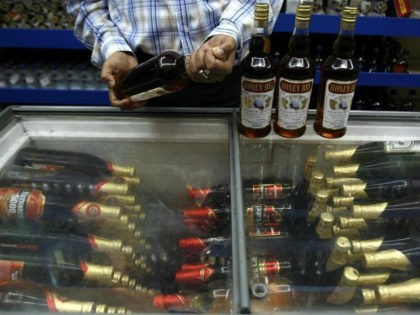 A man checks an alcohol bottle inside a wine shop in Siliguri August 19, 2008. REUTERS/Rup