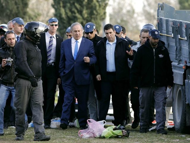 Israeli Prime Minister Benjamin Netanyahu (C) visits the site of a vehicle-ramming attack