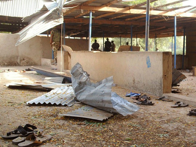 Nigeria troops, rear, provide security at the area where a bomb exploded in Nigeria's nort