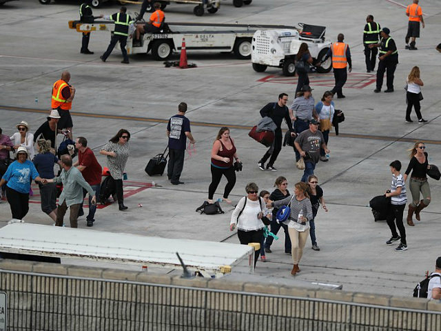 FORT LAUDERDALE, FL - JANUARY 06: People seek cover on the tarmac of Fort Lauderdale-Holly