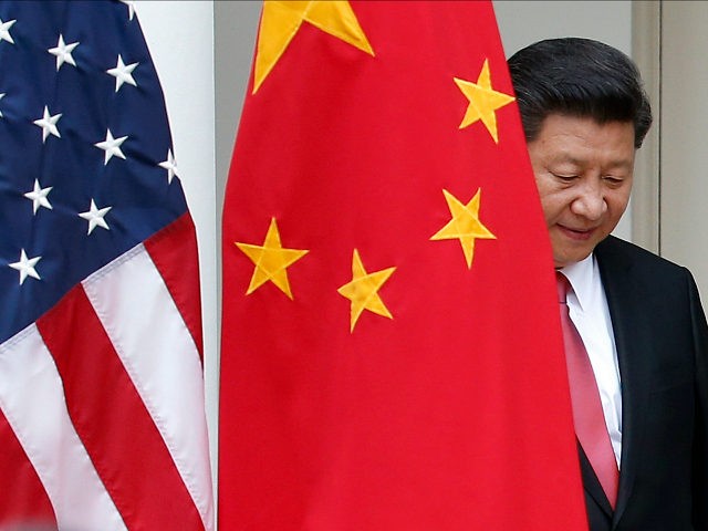Chinese President Xi Jinping steps out from behind China's flag as he takes his position f