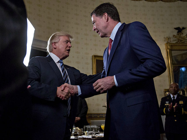 WASHINGTON, DC - JANUARY 22: U.S. President Donald Trump (C) shakes hands with James Comey, director of the Federal Bureau of Investigation (FBI), during an Inaugural Law Enforcement Officers and First Responders Reception in the Blue Room of the White House on January 22, 2017 in Washington, DC. Trump today …