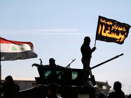 A Shi'ite fighter stands on top of a vehicle at a check point near Bartella, Iraq, Novembe