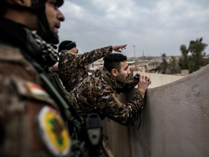Iraqi members of the Special Forces scan the area held by Islamic state militants from a r