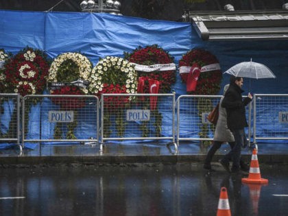 A couple walk past the Reina nightclub on January 5, 2017 in Istanbul, days after a gunman